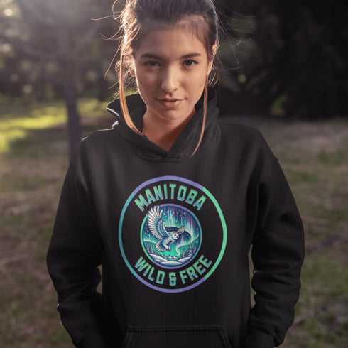 Embrace the magic of the prairies with our Manitoba – Wild & Free hoodie, featuring a captivating graphic of a snowy owl in flight beneath the shimmering northern lights.